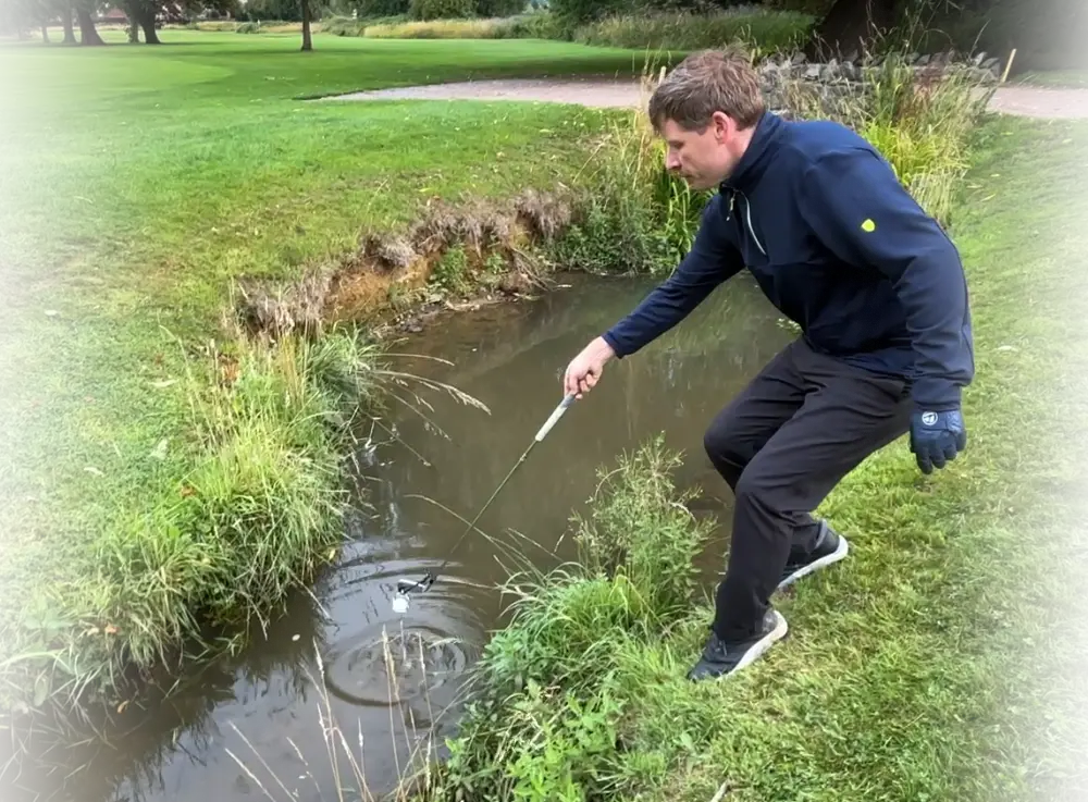 ClubScoop attached to clubface holding a golf ball